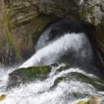 Wasser umspült kraftvoll einen Felsen