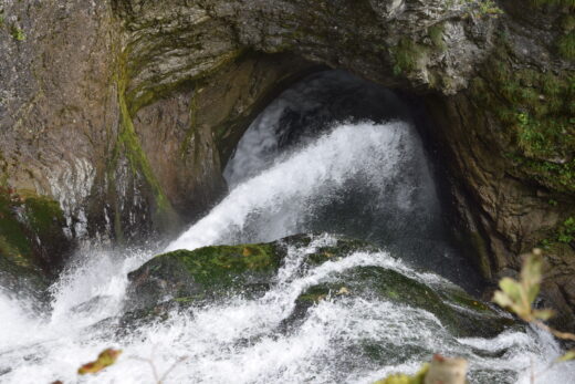 Wasser umspült kraftvoll einen Felsen