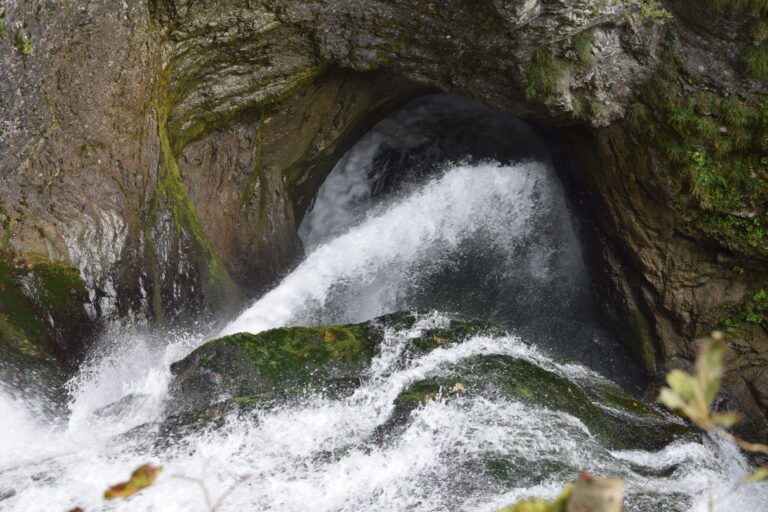 Wasser umspült kraftvoll einen Felsen